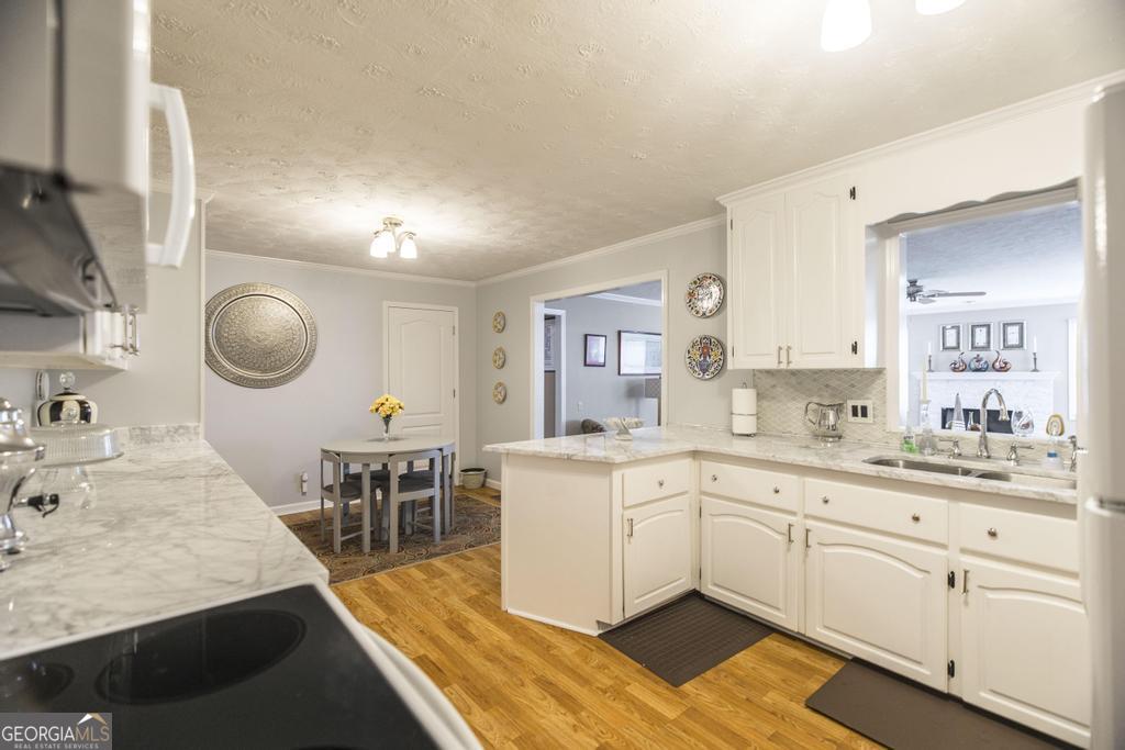 209 Spillers Street Fort Valley, GA 31030 - Photo 10 of 36 a large white kitchen with cabinets a sink a window and stainless steel appliances