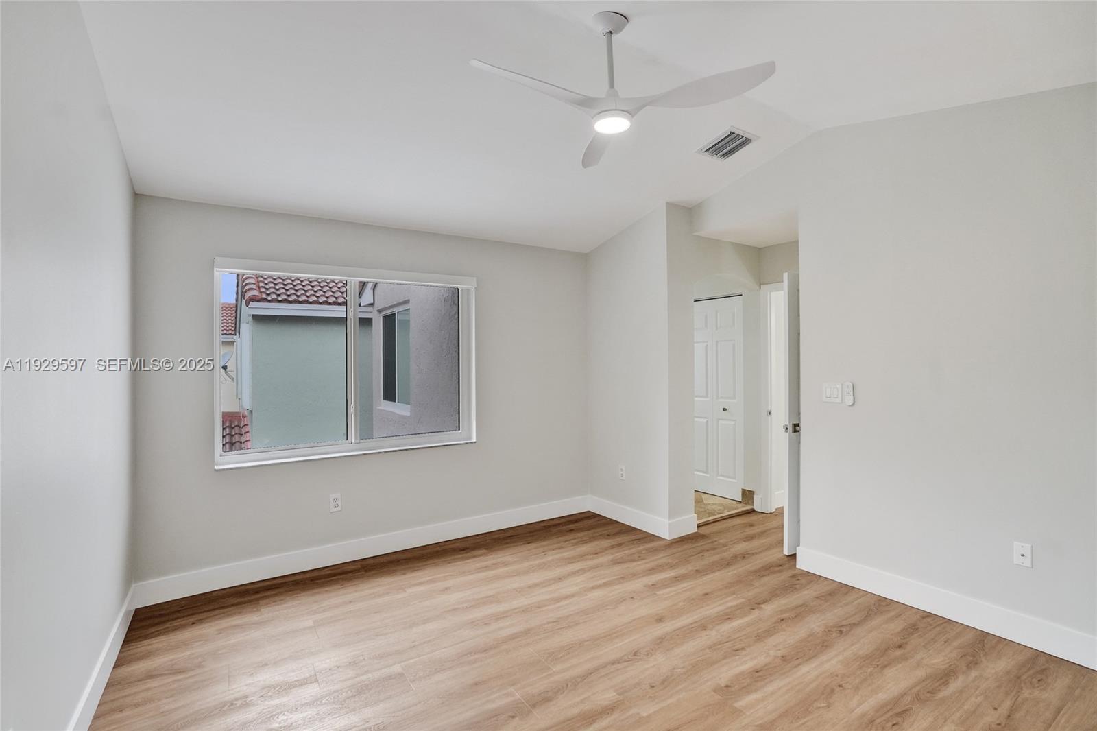 4120 Fern Forest Road Cooper City, FL 33026 - Photo 16 of 44 an empty room with wooden floor a ceiling fan and windows