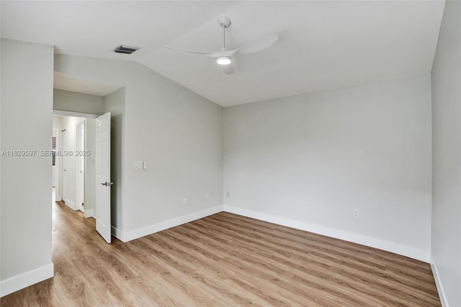 4120 Fern Forest Road Cooper City, FL 33026 - Photo 17 of 44 a view of an empty room with wooden floor and a window