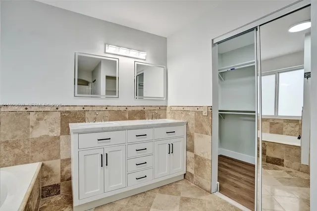a bathroom with a double vanity sink and mirror