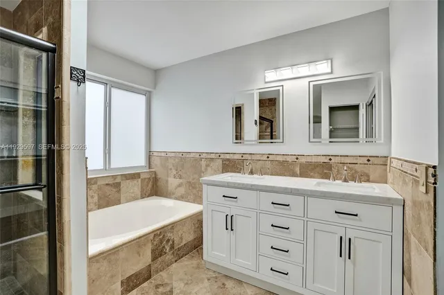 a bathroom with a granite countertop sink mirror and bathtub