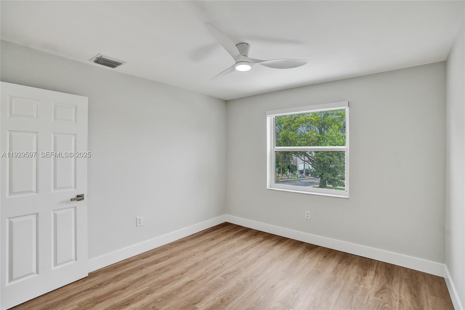 4120 Fern Forest Road Cooper City, FL 33026 - Photo 25 of 44 a view of an empty room with wooden floor and a window