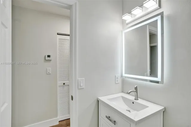 a bathroom with a sink a light fixture and a mirror