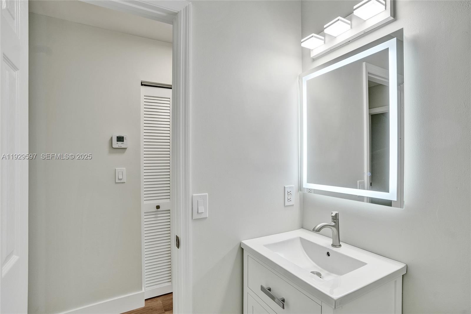 4120 Fern Forest Road Cooper City, FL 33026 - Photo 32 of 44 a bathroom with a sink a light fixture and a mirror