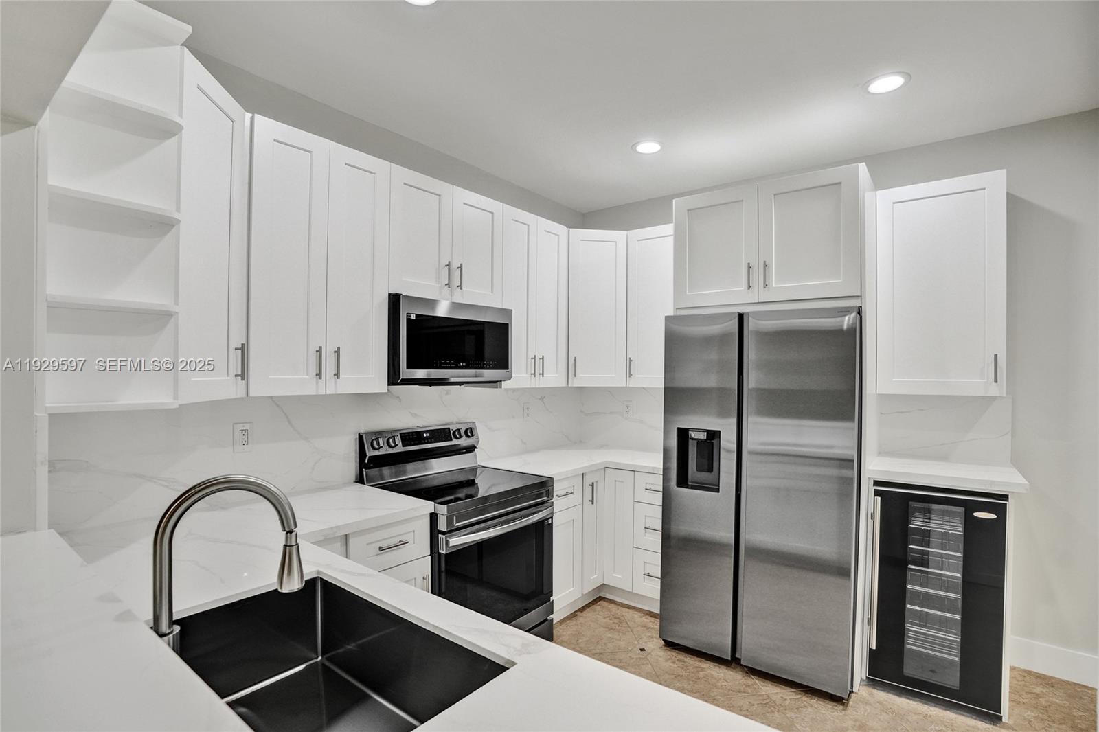 4120 Fern Forest Road Cooper City, FL 33026 - Photo 4 of 44 a kitchen with stainless steel appliances a refrigerator sink and white cabinets