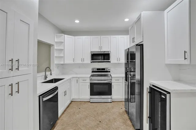a kitchen with stainless steel appliances granite countertop a stove a sink and a refrigerator