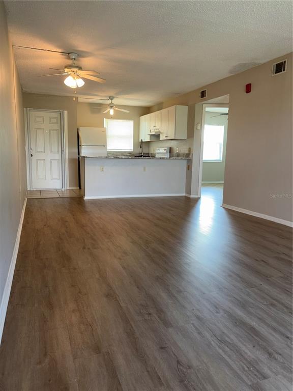 26485 Rampart Boulevard, Unit D1 Punta Gorda, FL 33983 - Photo 3 of 29 a view of a big room with wooden floor and a kitchen