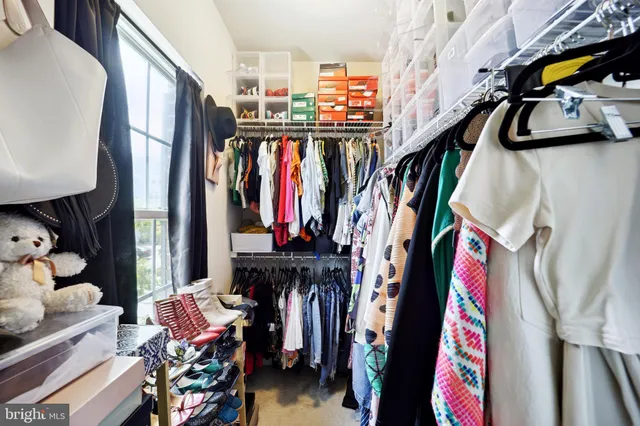 a view of walk in closet with clothes and shoes