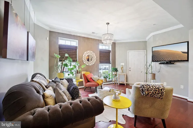 a living room with furniture a chandelier and a flat screen tv