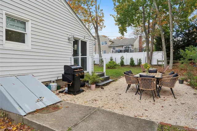 a view of a patio with table and chairs and floor to ceiling window