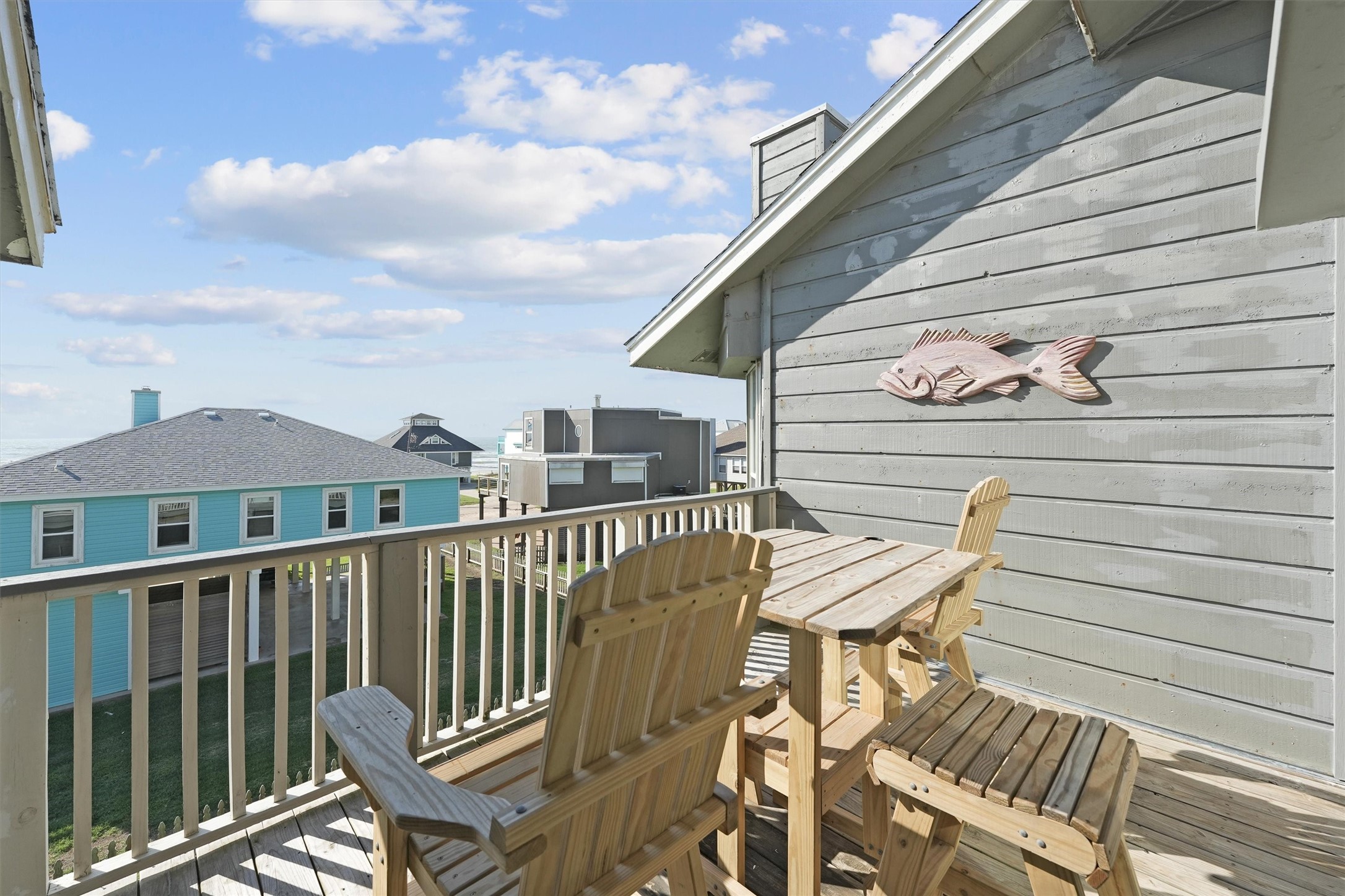 17607 Termini-San Luis Pass Road Galveston, TX 77554 - Photo 8 of 42 The balcony’s wooden Adirondack chairs invite you to take in the scenery while dining or lounging outdoors. This tranquil space is ideal for enjoying the serene beach atmosphere just steps away from home.