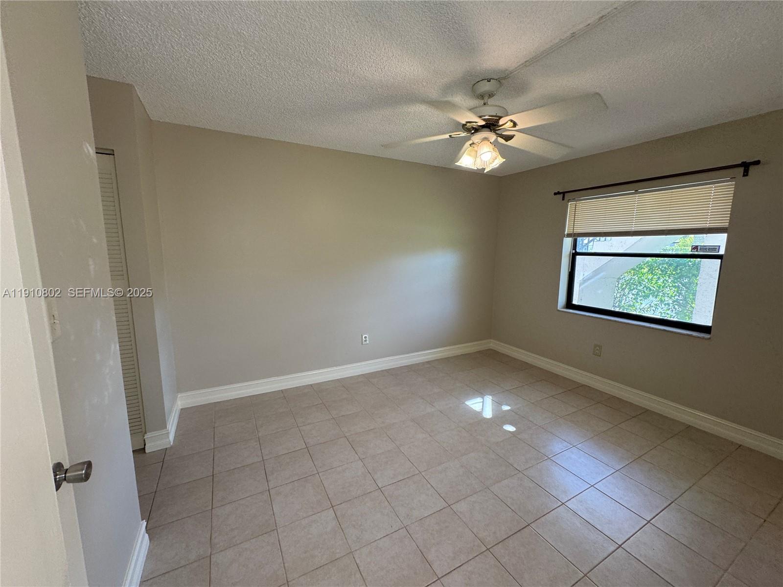 6031 Shaker Wood Circle, Unit 101 Tamarac, FL 33319 - Photo 17 of 28 an empty room with closet and a chandelier fan