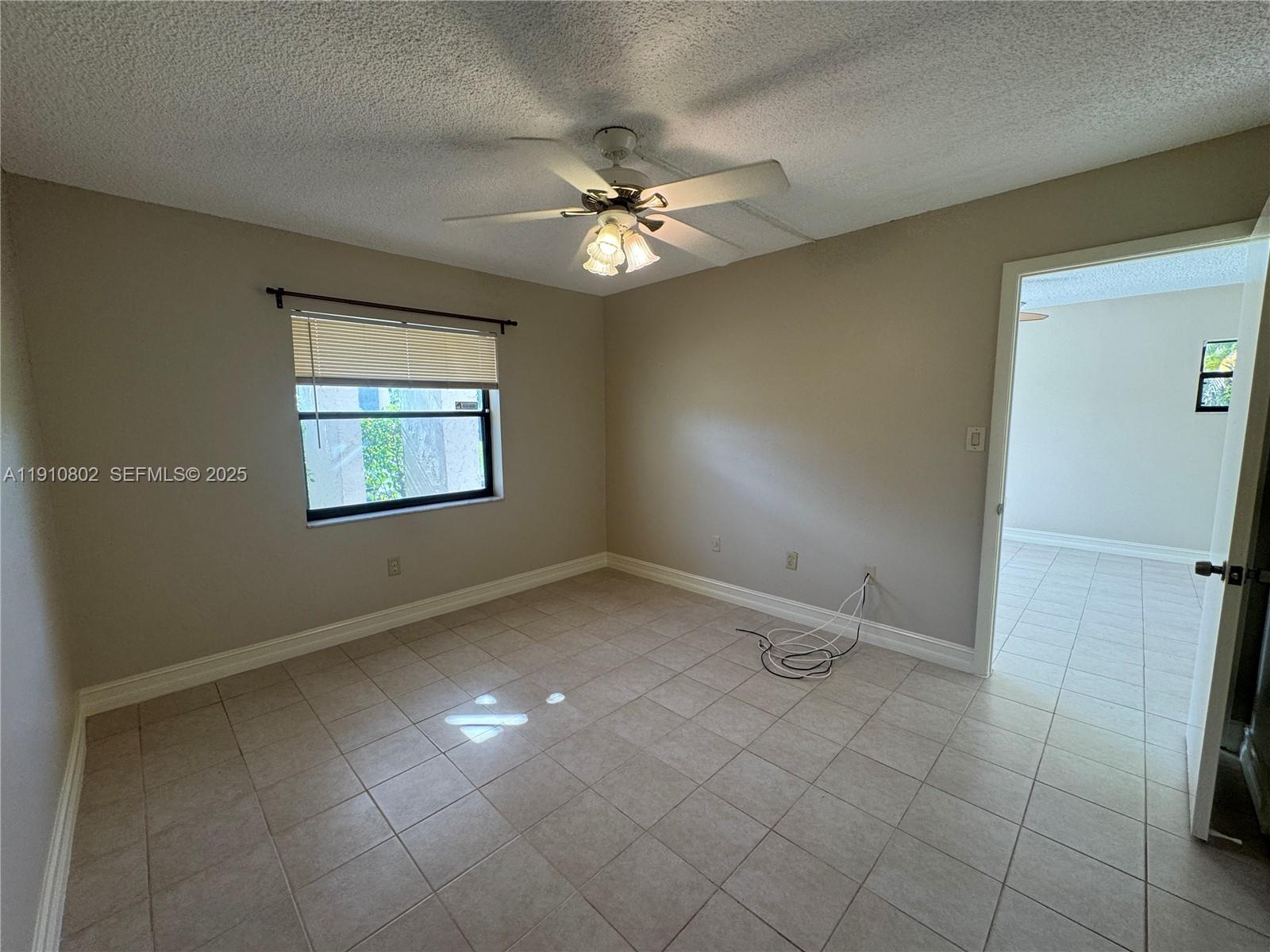 6031 Shaker Wood Circle, Unit 101 Tamarac, FL 33319 - Photo 18 of 28 an empty room with windows and fan