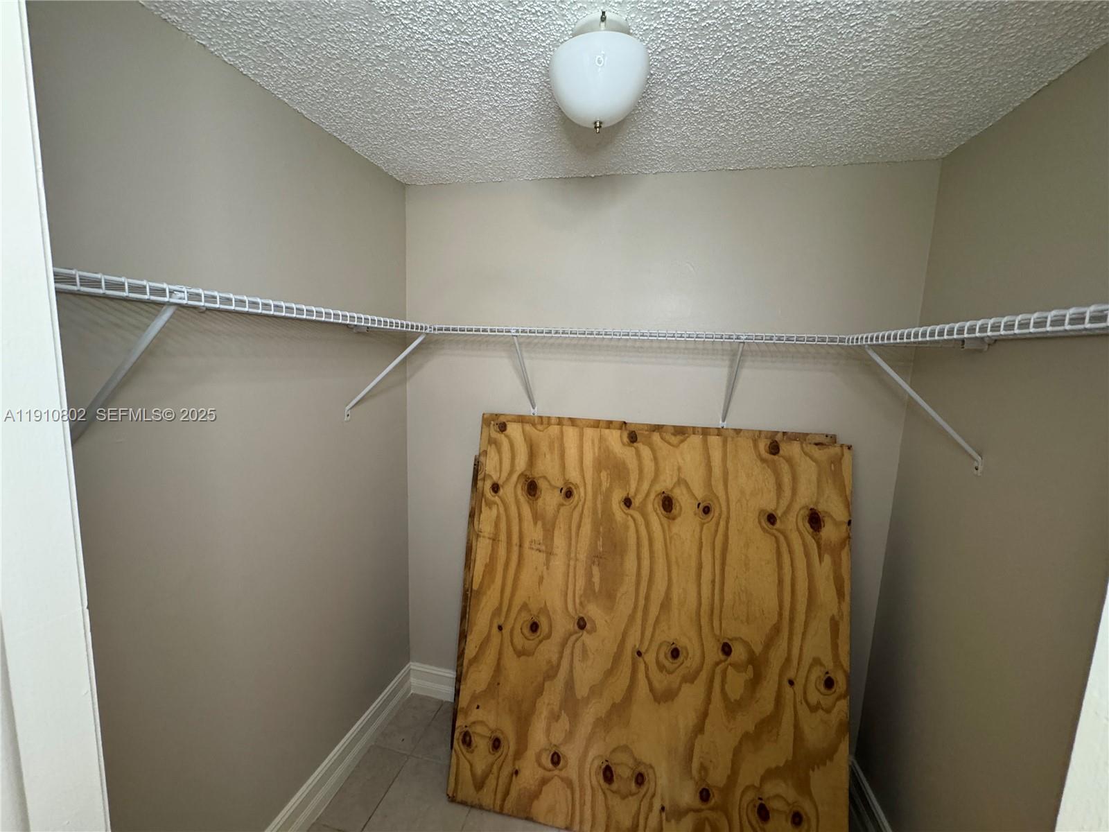 6031 Shaker Wood Circle, Unit 101 Tamarac, FL 33319 - Photo 25 of 28 a bathroom with a shower and a mirror