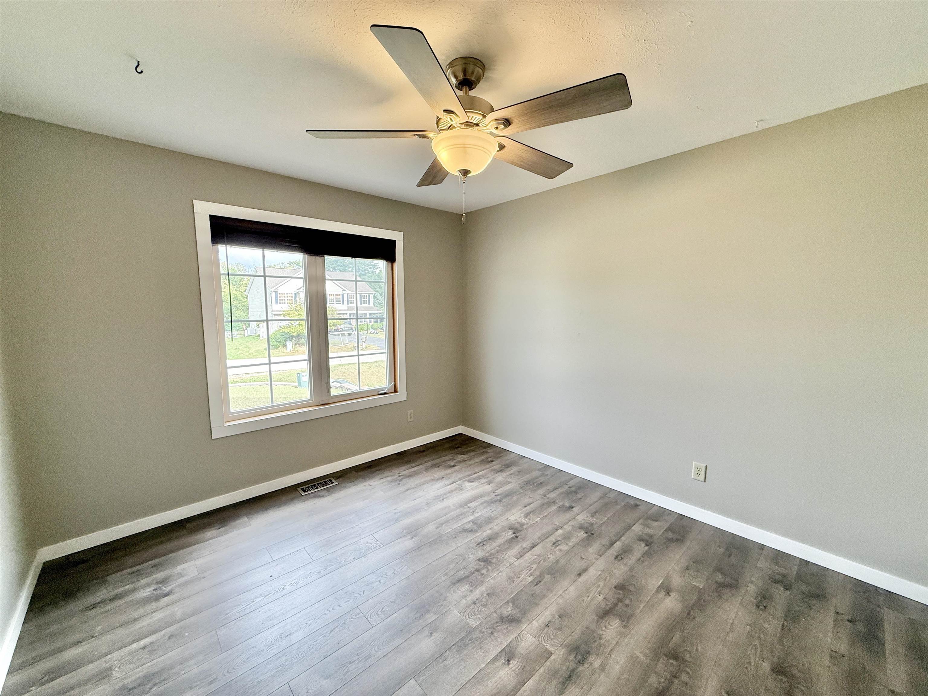 11008 Chicory Ridge Way Roscoe, IL 61073 - Photo 18 of 45 an empty room with wooden floor fan and windows
