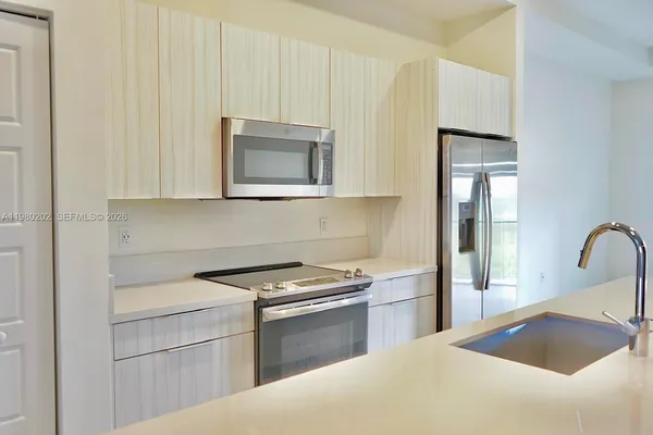 a kitchen with granite countertop white cabinets and stainless steel appliances