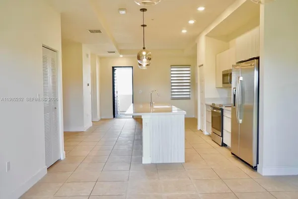 a view of a kitchen with a refrigerator and a sink
