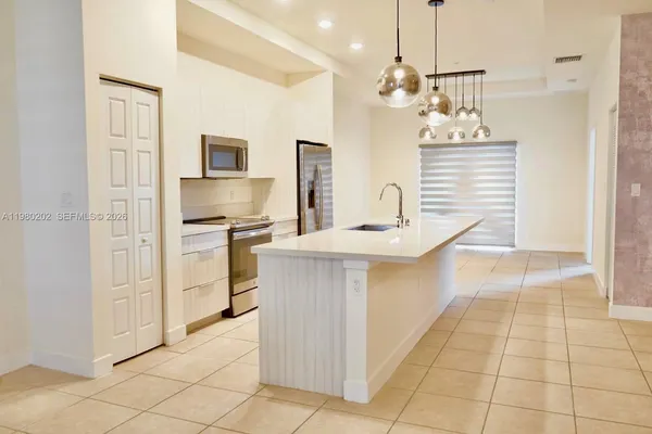 a kitchen with kitchen island cabinets and refrigerator