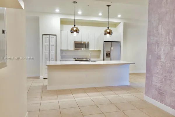 a large kitchen with kitchen island a sink stainless steel appliances and cabinets