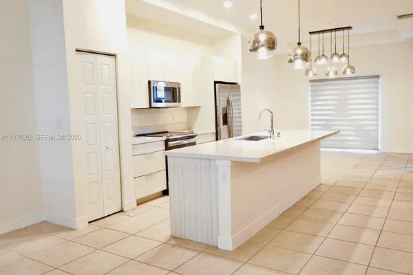 a kitchen with kitchen island cabinets and refrigerator