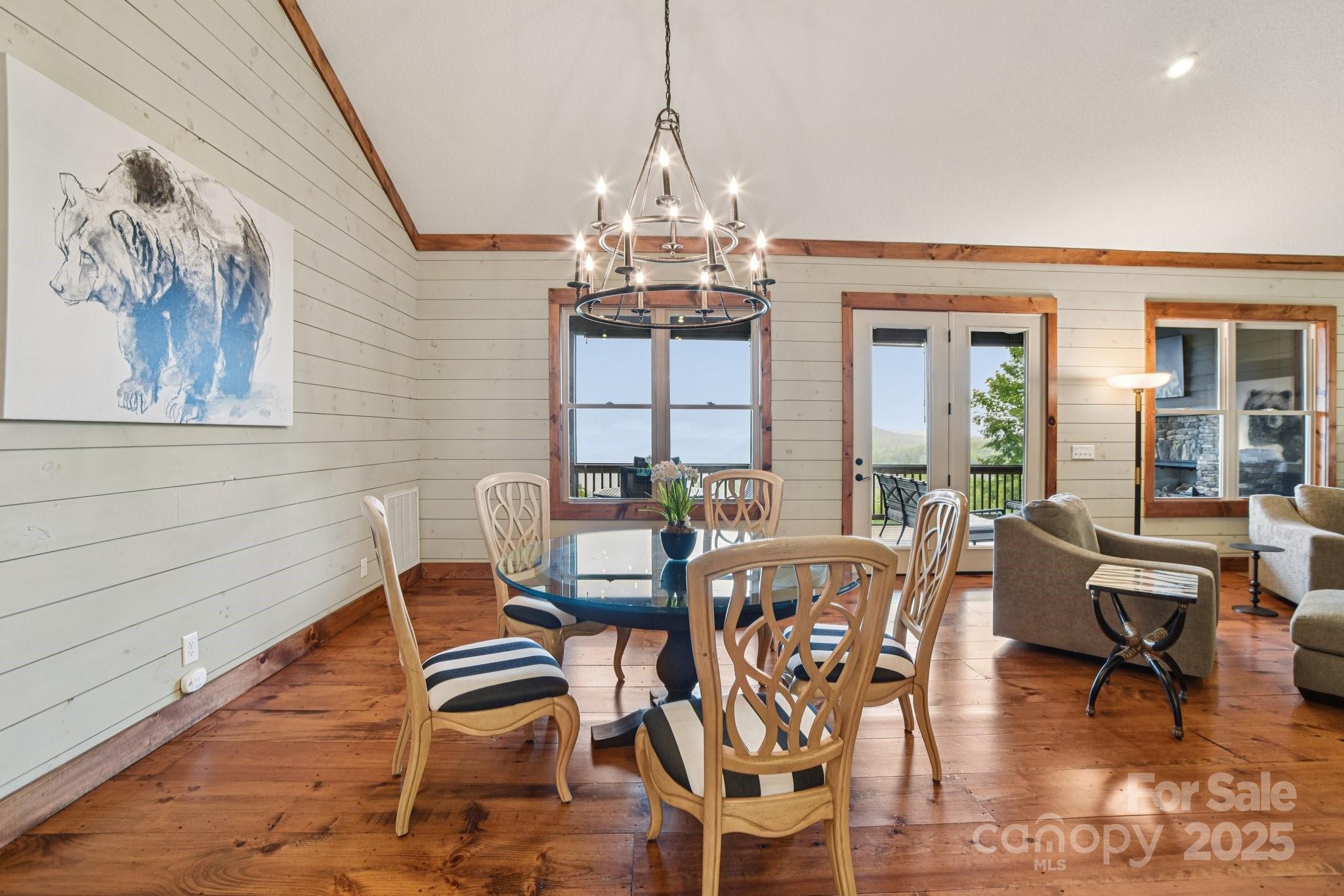 71 Raptor Way Sapphire, NC 28774 - Photo 12 of 46 a dining room with wooden floor a chandelier a glass table and chairs