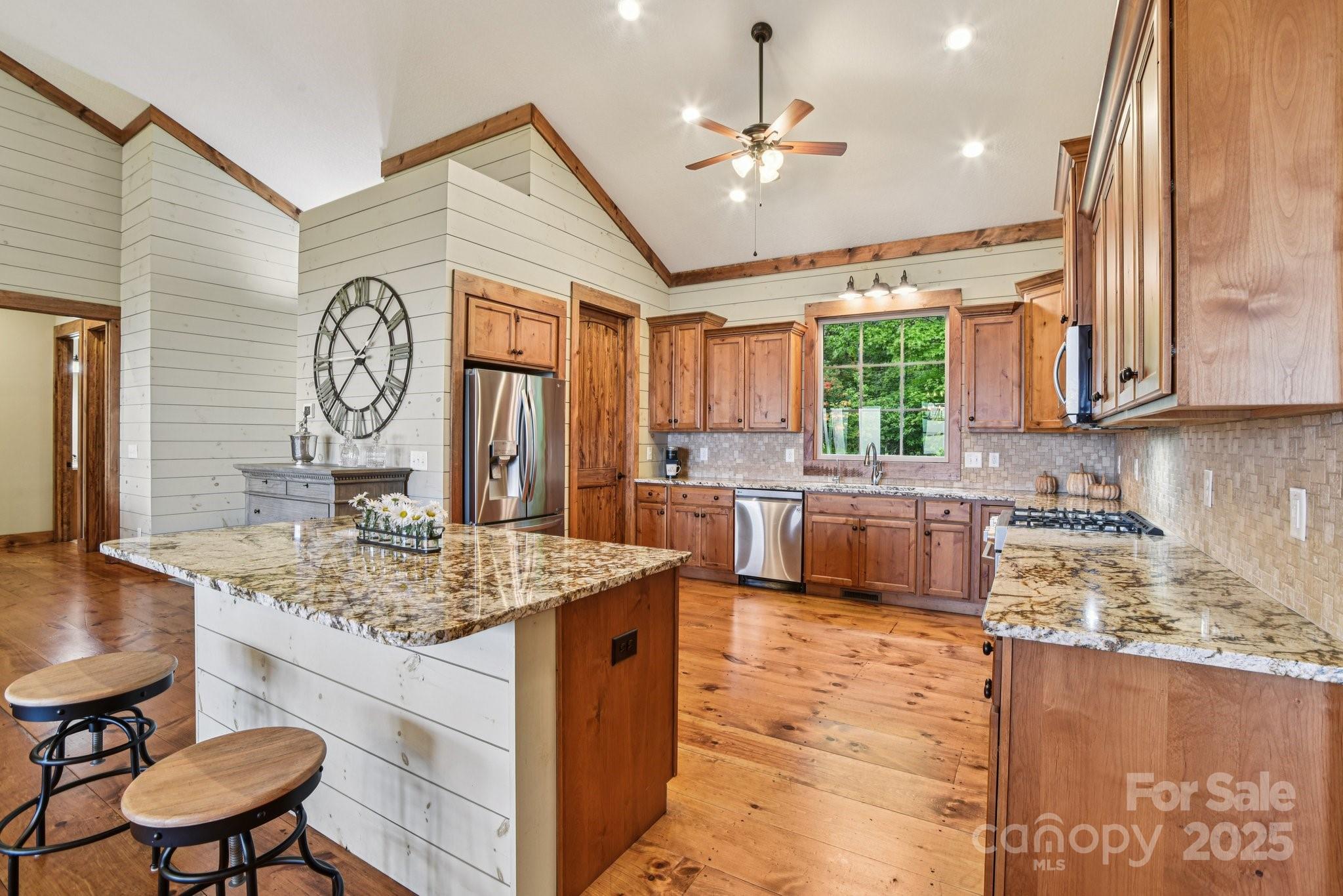 71 Raptor Way Sapphire, NC 28774 - Photo 13 of 46 a kitchen with stainless steel appliances granite countertop wooden cabinets a stove a sink a dining table and chairs