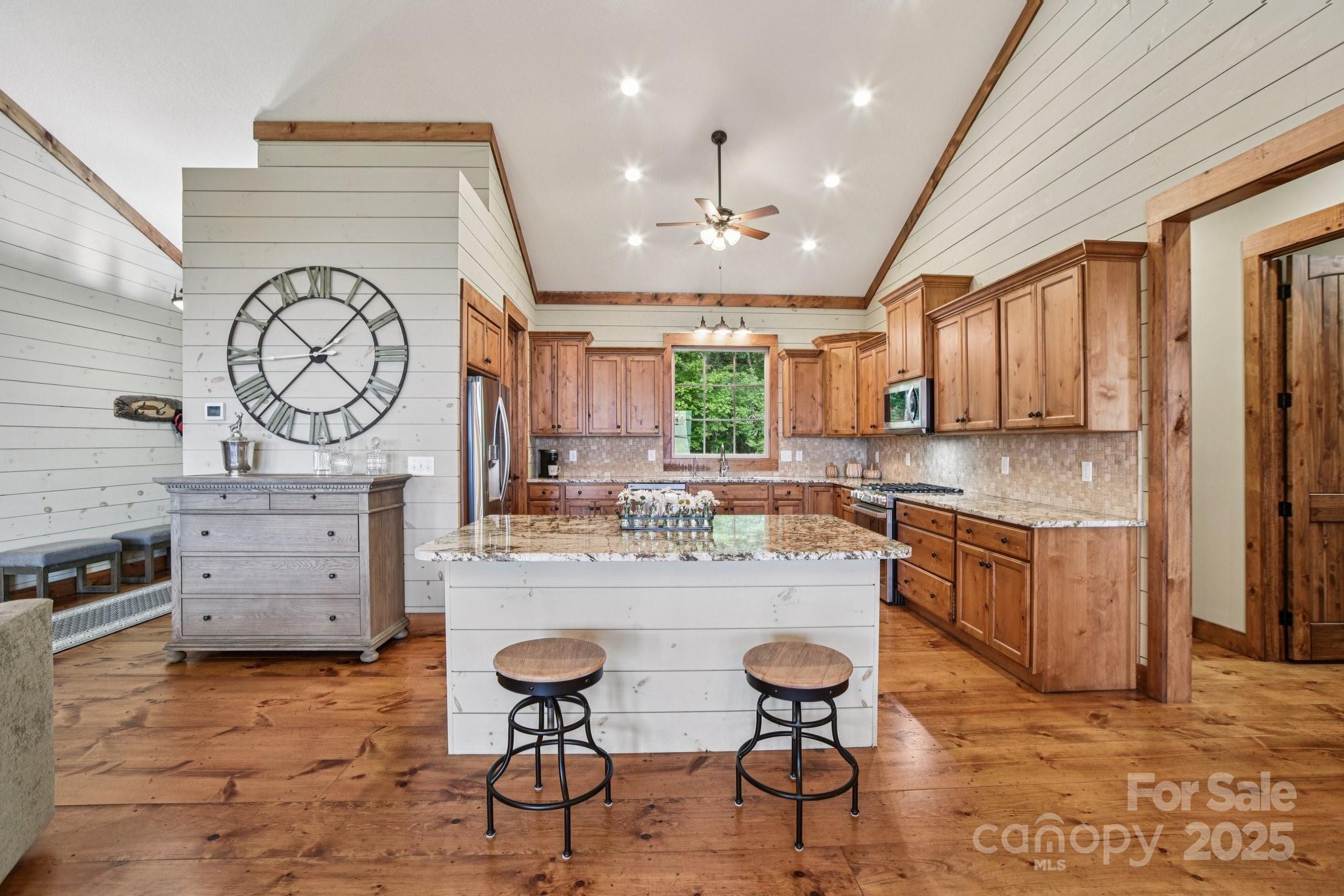 71 Raptor Way Sapphire, NC 28774 - Photo 14 of 46 a kitchen with stainless steel appliances granite countertop a stove a sink dishwasher and a refrigerator with wooden cabinets
