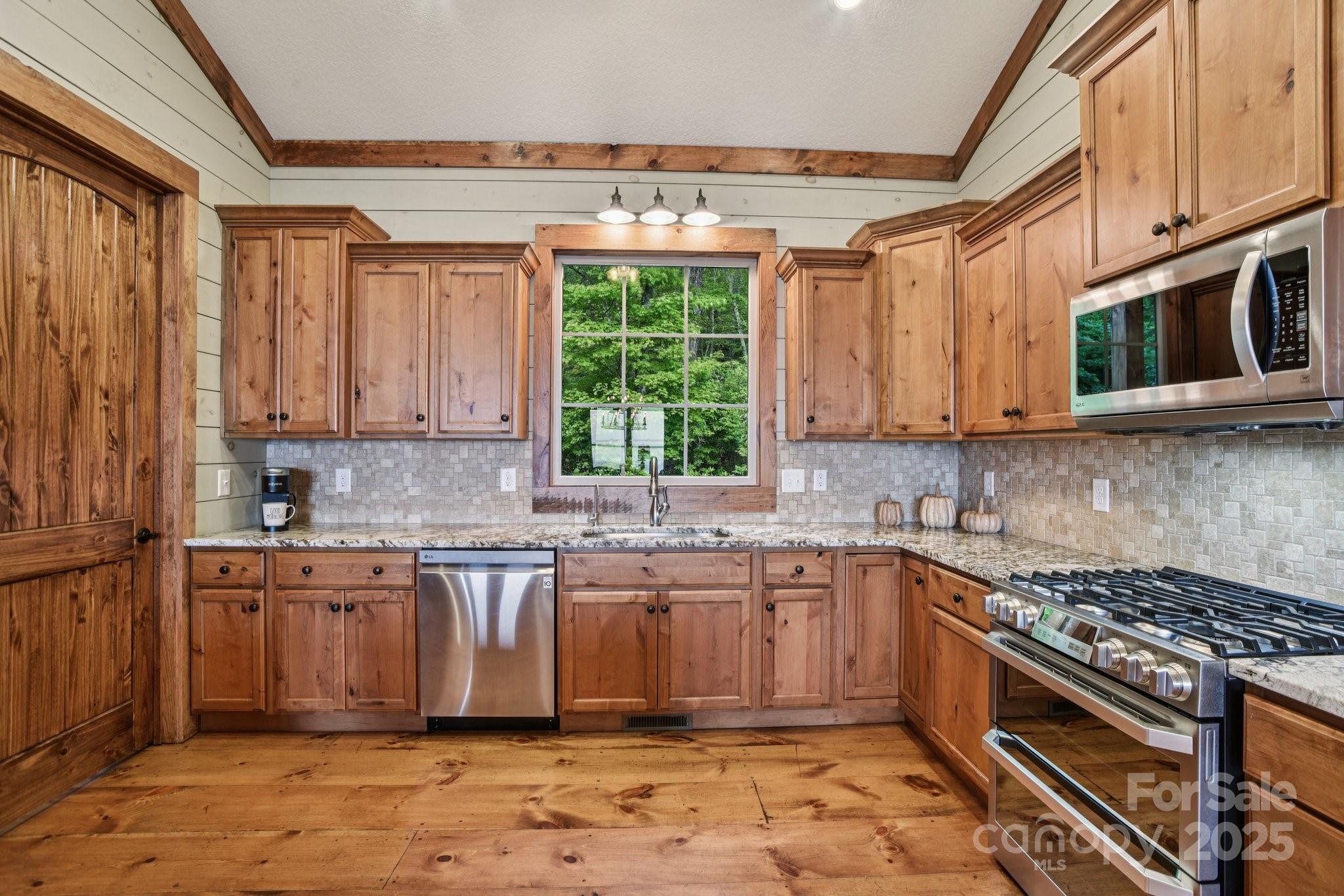 71 Raptor Way Sapphire, NC 28774 - Photo 15 of 46 a kitchen with stainless steel appliances granite countertop a stove a sink and a microwave