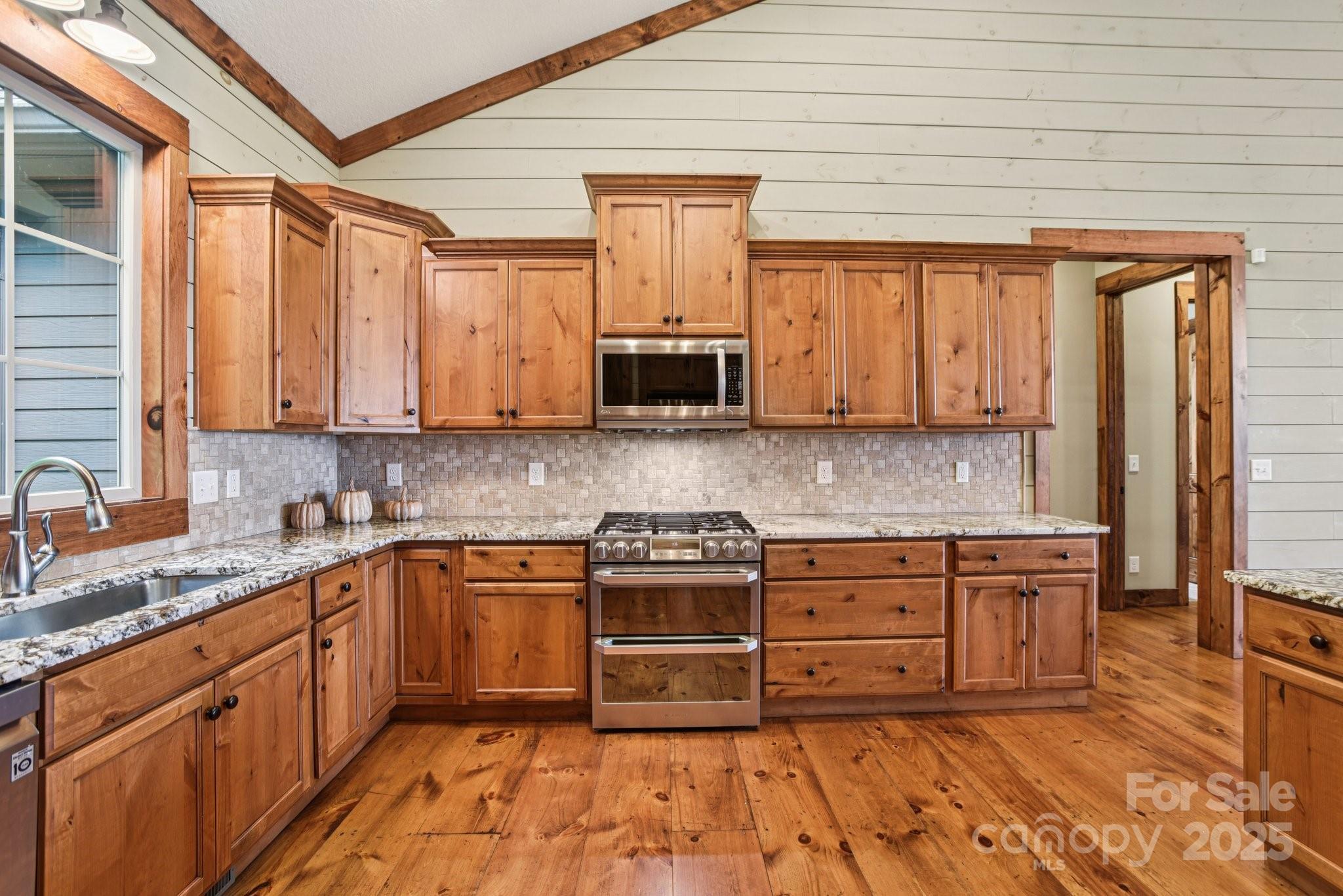 71 Raptor Way Sapphire, NC 28774 - Photo 16 of 46 a kitchen with stainless steel appliances granite countertop wooden cabinets granite counter tops and a window