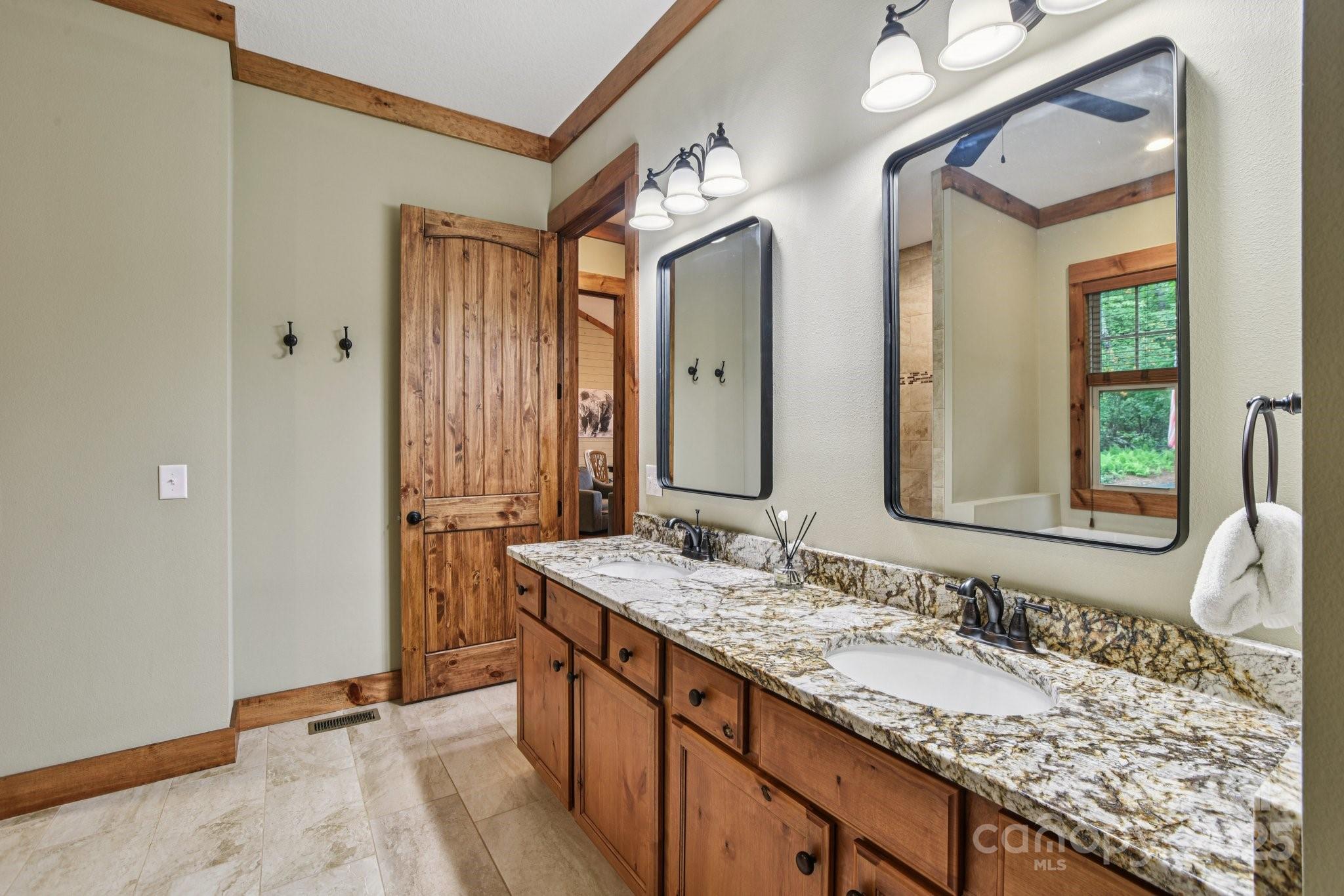71 Raptor Way Sapphire, NC 28774 - Photo 27 of 46 a bathroom with a granite countertop double vanity sink and a mirror