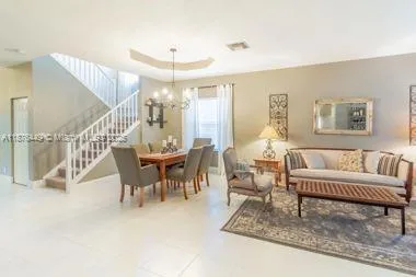 a living room with furniture and a dining table
