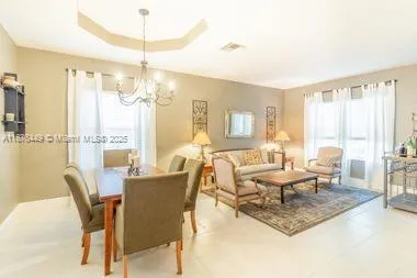 a living room with furniture a large window and a dining table