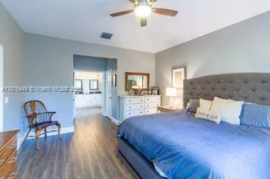 a spacious bedroom with a bed and chair