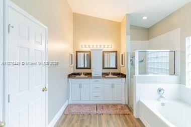 8525 Pine Cay West Palm Beach, FL 33411 - Photo 27 of 40 a bathroom with a granite countertop sink a mirror and a bathtub
