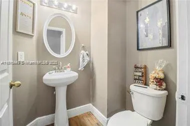 a bathroom with a toilet sink and mirror