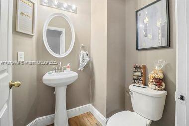 8525 Pine Cay West Palm Beach, FL 33411 - Photo 30 of 40 a bathroom with a toilet sink and mirror