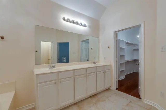 a spacious bathroom with a double vanity sink and a mirror
