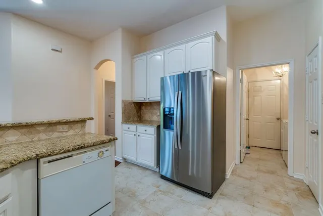 a kitchen with stainless steel appliances granite countertop a refrigerator and a sink