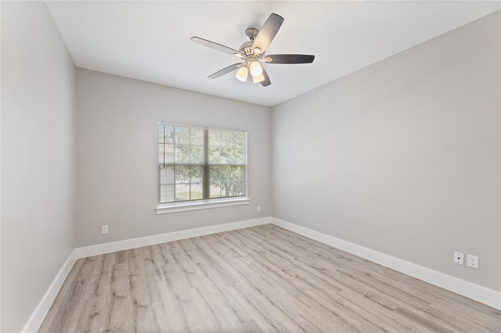 13609 Pinnacle Circle West, Unit 1102 Fort Worth, TX 76040 - Photo 16 of 21 an empty room with wooden floor and windows