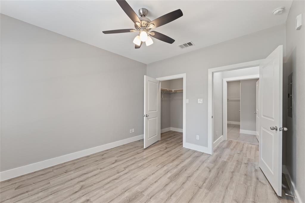 13609 Pinnacle Circle West, Unit 1102 Fort Worth, TX 76040 - Photo 18 of 21 an empty room with wooden floor and a ceiling fan