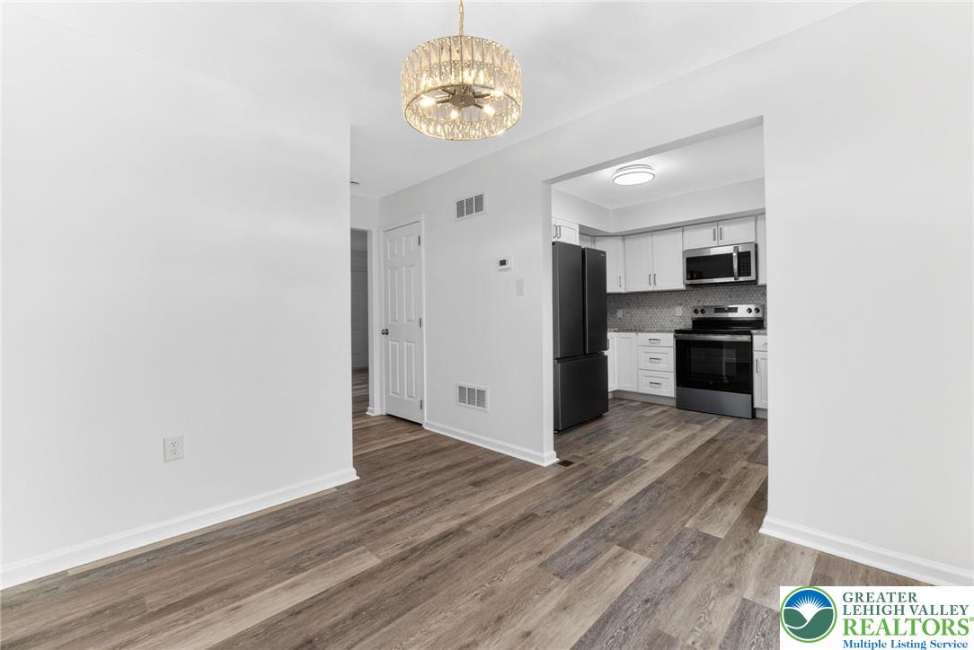 708 Cherokee Street Bethlehem, PA 18015 - Photo 10 of 25 an empty room with wooden floor kitchen view and a window