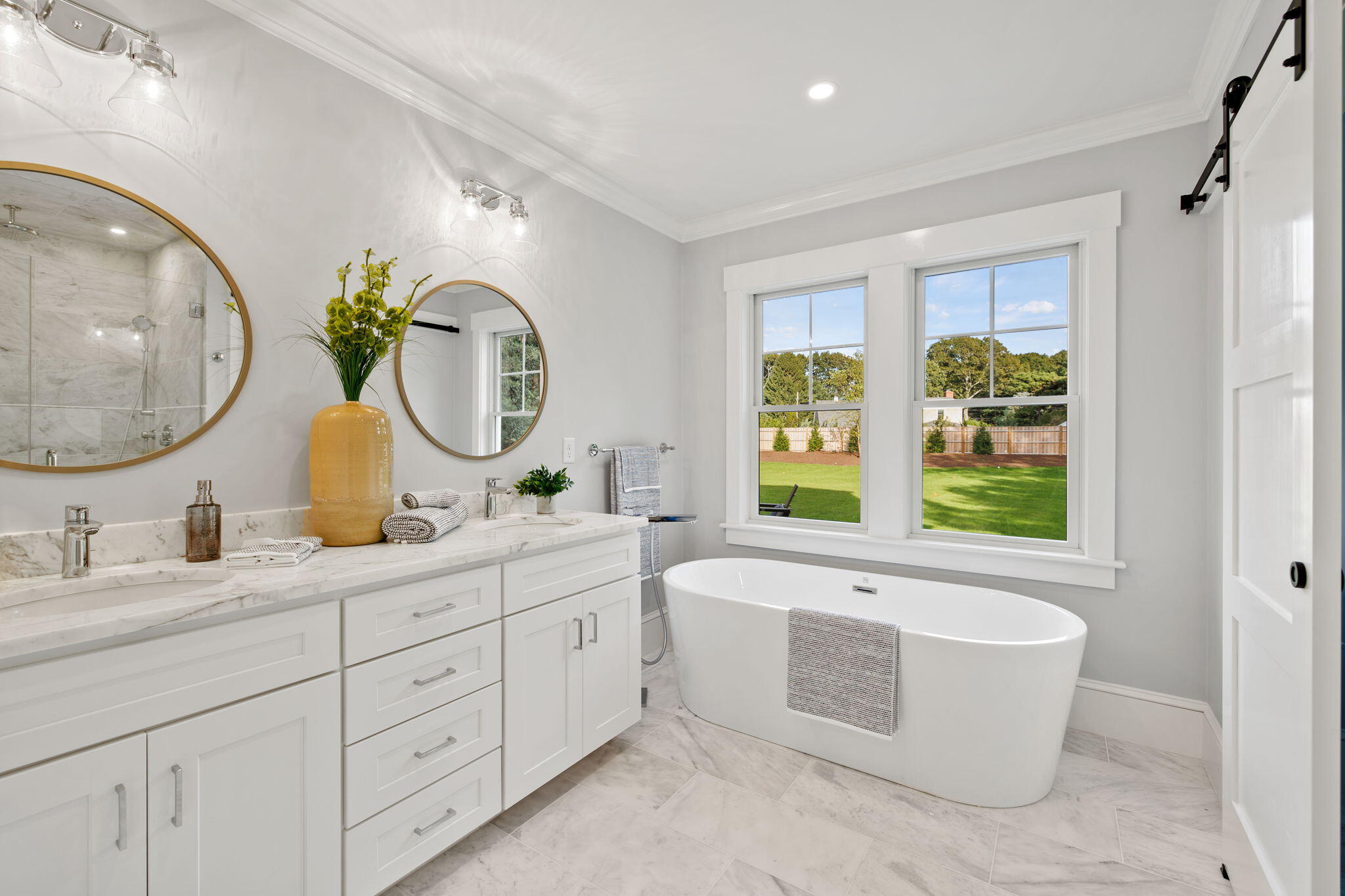 76 Old Mill Road Osterville, MA 02655 - Photo 30 of 45 a spacious bathroom with a double vanity sink a large mirror and a bathtub