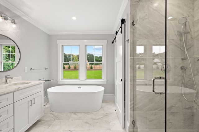 a bathroom with a tub sink shower and mirror