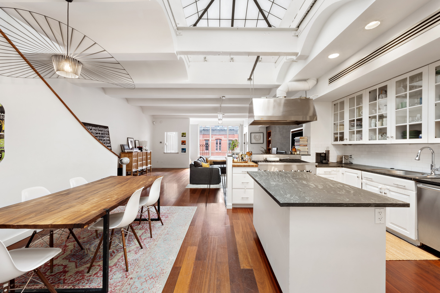 176 Franklin Street, Unit PH Manhattan, NY 10013 - Photo 4 of 5 a kitchen with stainless steel appliances granite countertop lots of counter space and wooden floors