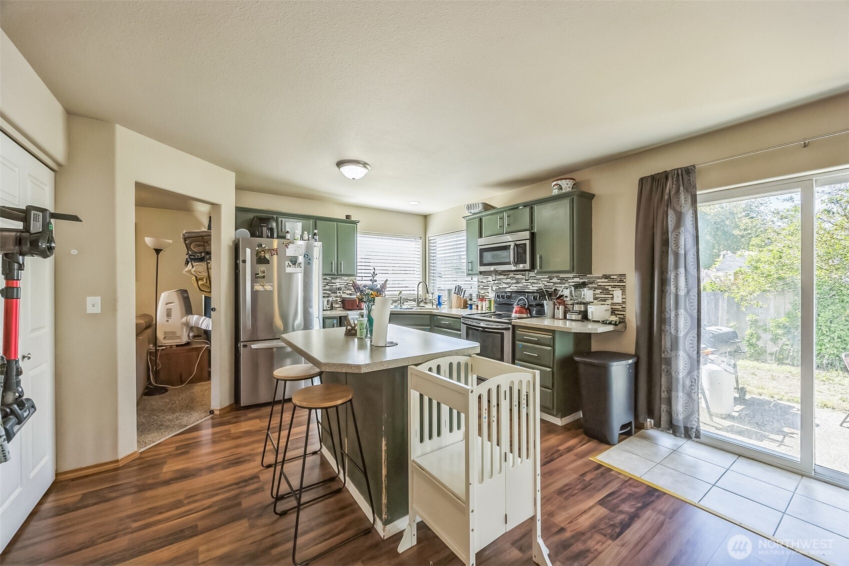 201 3rd Street Northeast Yelm, WA 98597 - Photo 13 of 30 a kitchen with stainless steel appliances kitchen island granite countertop a refrigerator a stove a sink dishwasher with a dining table and chairs