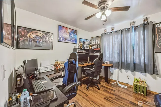 a view of a workspace with furniture and a ceiling fan