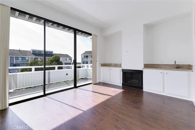 a view of a big room with wooden floor and windows