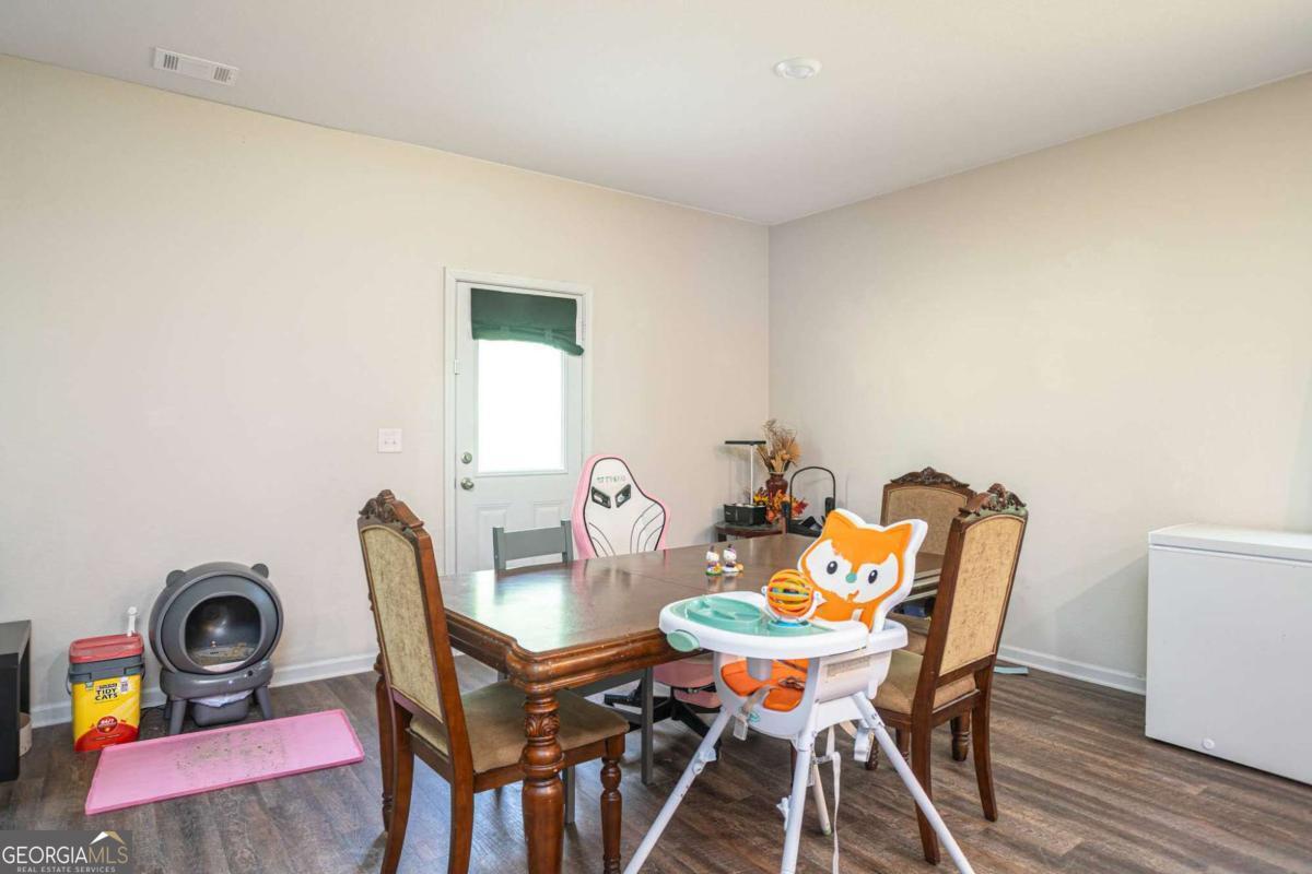 653 Meadows Farm Way Monroe, GA 30655 - Photo 16 of 34 a view of a dining room with furniture and wooden floor