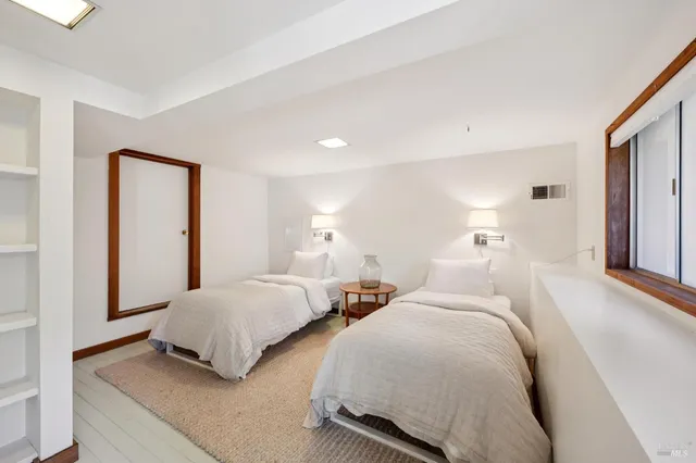 a bed sitting in a bedroom next to a window