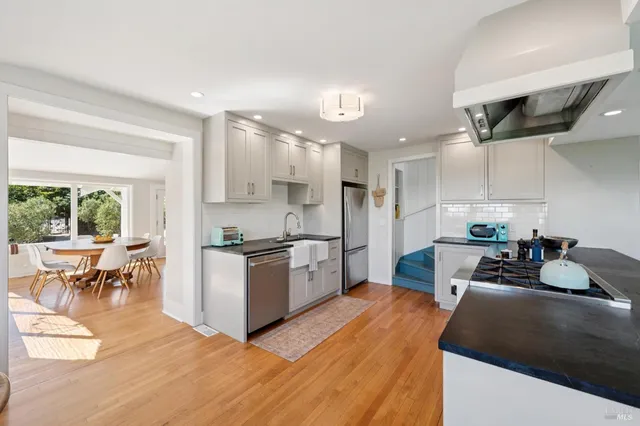 a large kitchen with kitchen island a large counter top space a sink a stove and a refrigerator